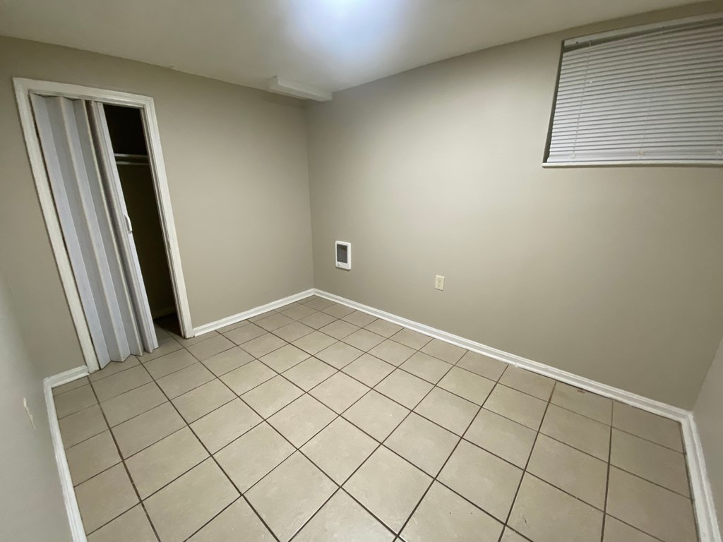 A room with a tiled floor and a door with a striped curtain.
