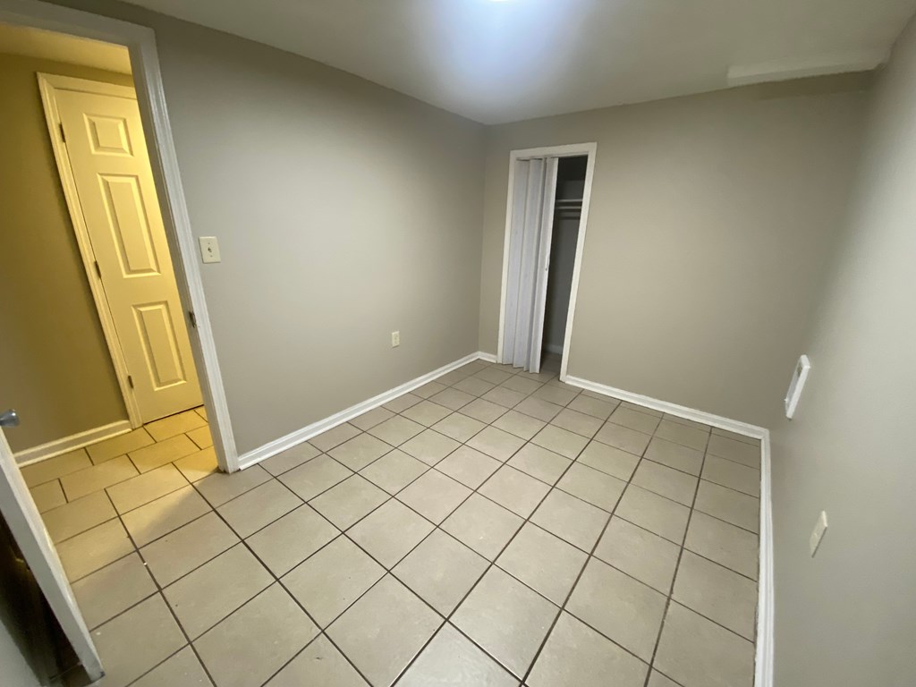 A room with a tiled floor and a door on the left.