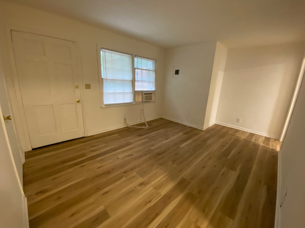 A room with wooden flooring and a window.