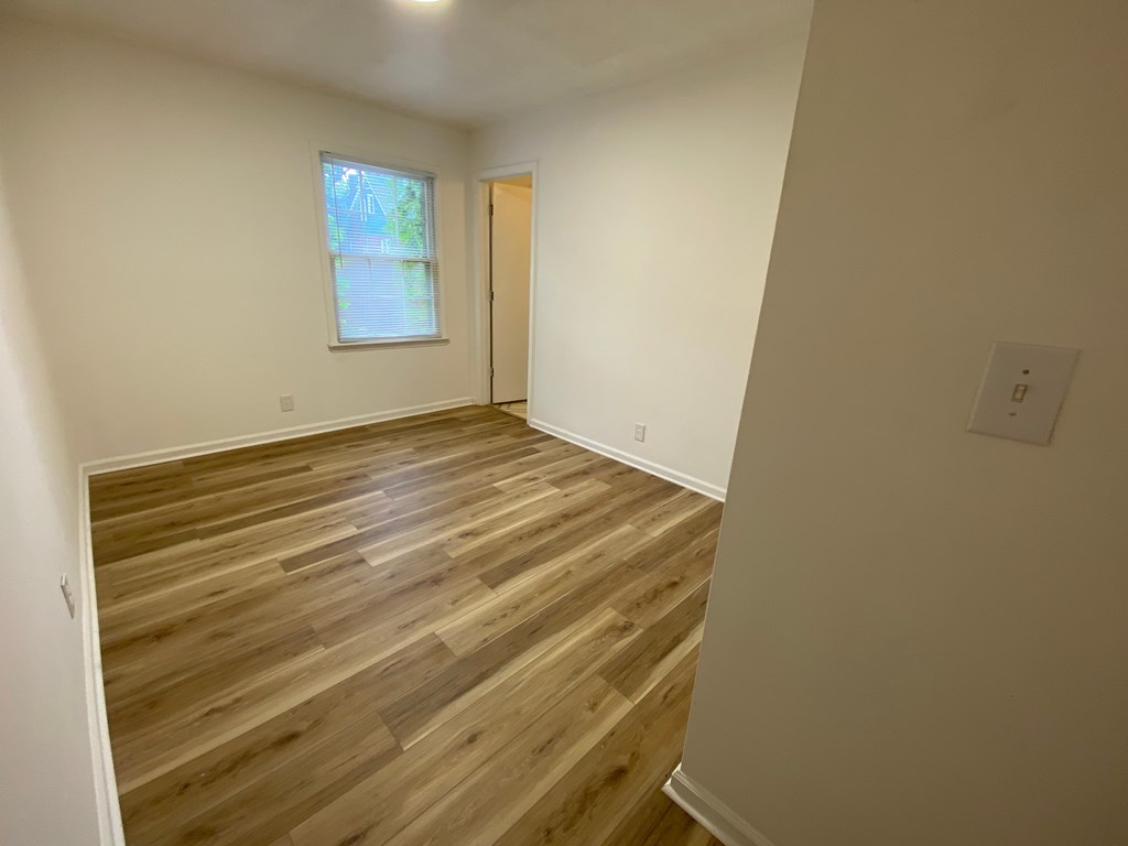 A room with wooden flooring and a window.