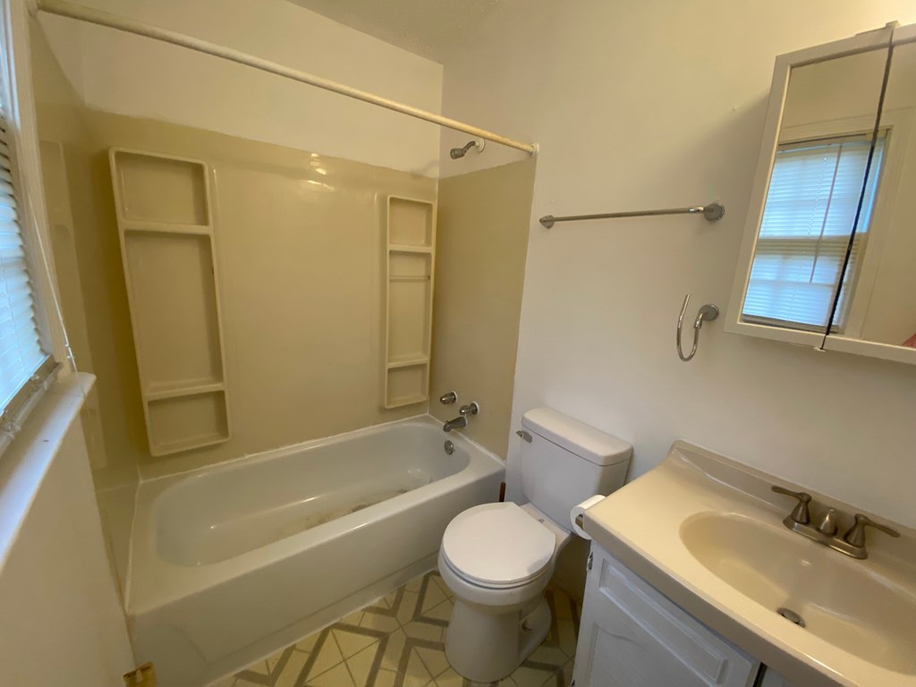 A white bathroom with a toilet, sink, and bathtub.