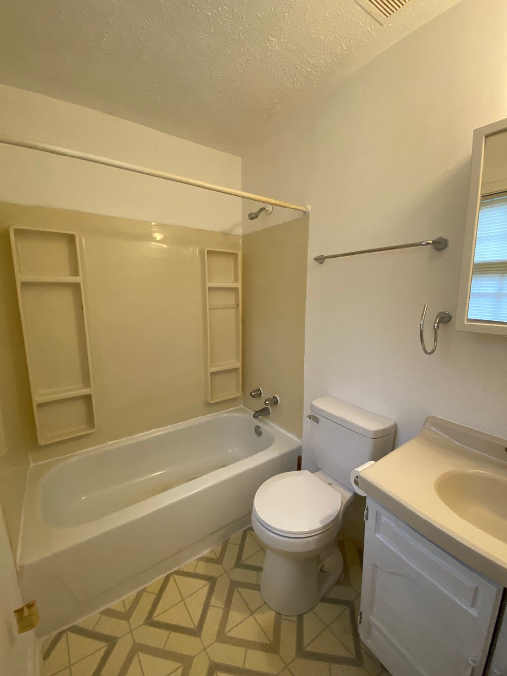 A white toilet sits next to a bathtub in a bathroom.