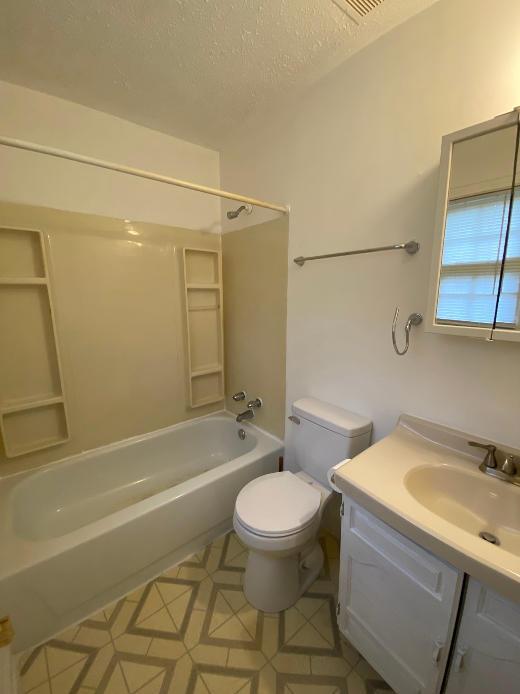 A white bathroom with a toilet, sink, and bathtub.