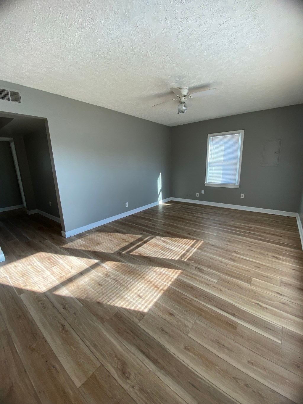 A room with wooden flooring and a ceiling fan.