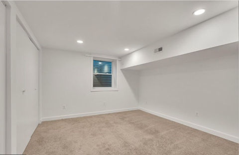 a white room with a window and carpet