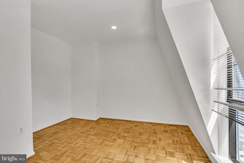 an empty room with wood flooring and a window