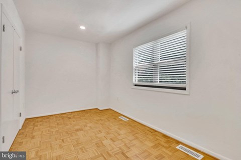 a living room with a window and wooden floors