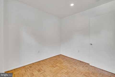 a room with wood flooring and white walls