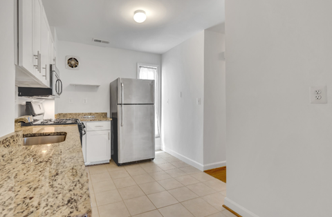 a kitchen with white cabinets and a stainless steel refrigerator