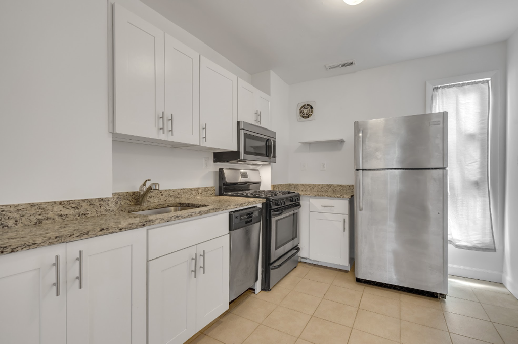 a kitchen with white cabinets and stainless steel appliances