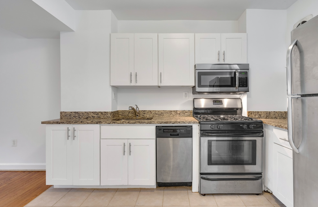 a kitchen with white cabinets and stainless steel appliances
