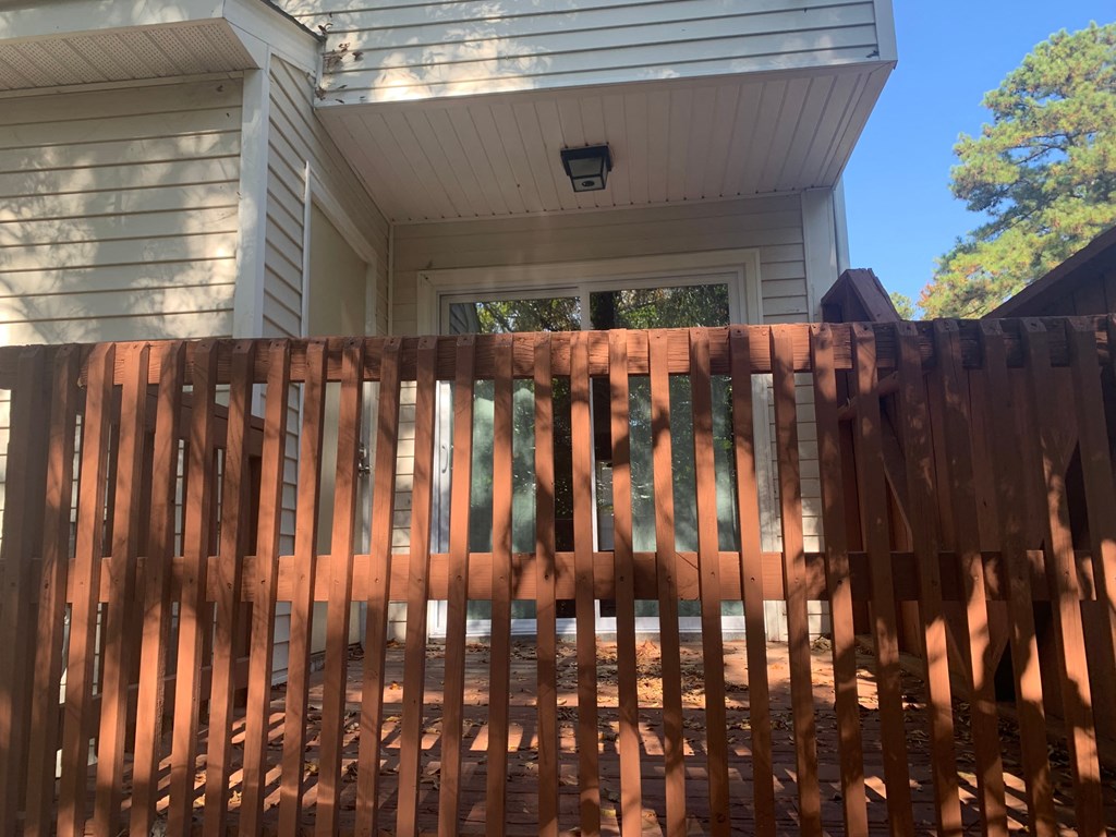 a backyard with a wooden fence and a house