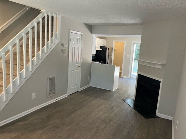 an empty living room with a staircase and a white door