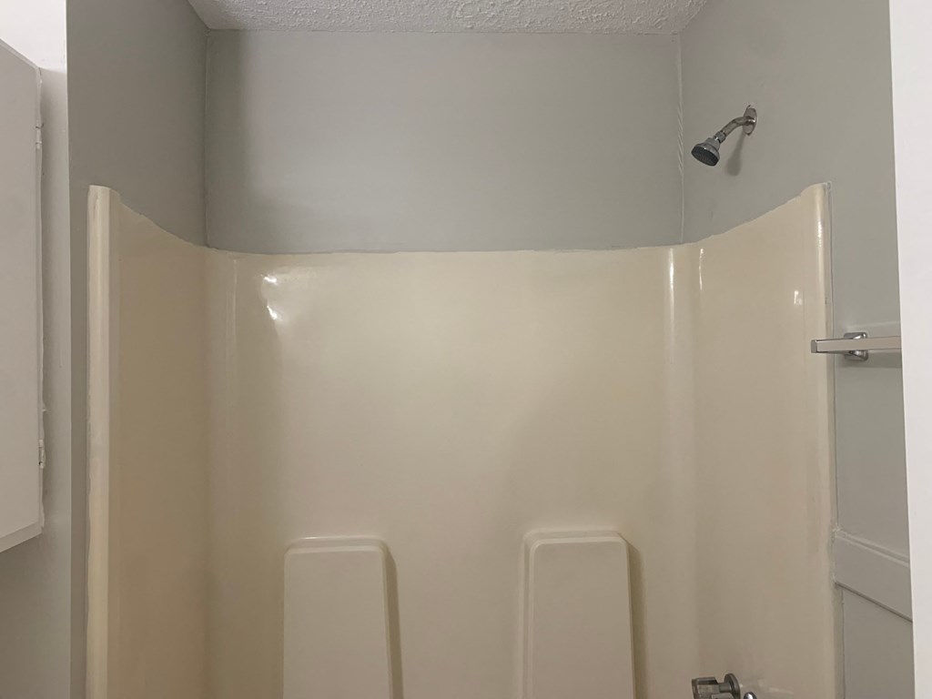 a white shower stall in a bathroom with a shower head