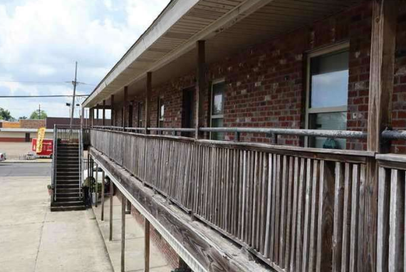 a building with a wooden porch and a brick wall