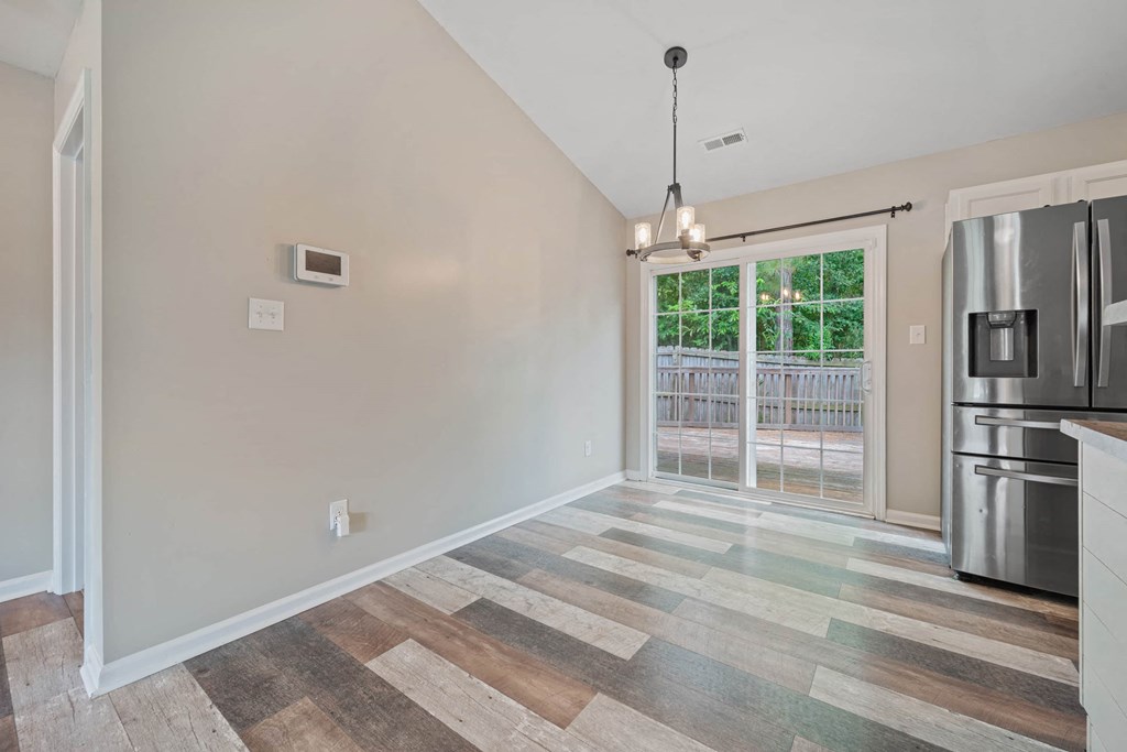 a kitchen with a stainless steel refrigerator and a sliding glass door