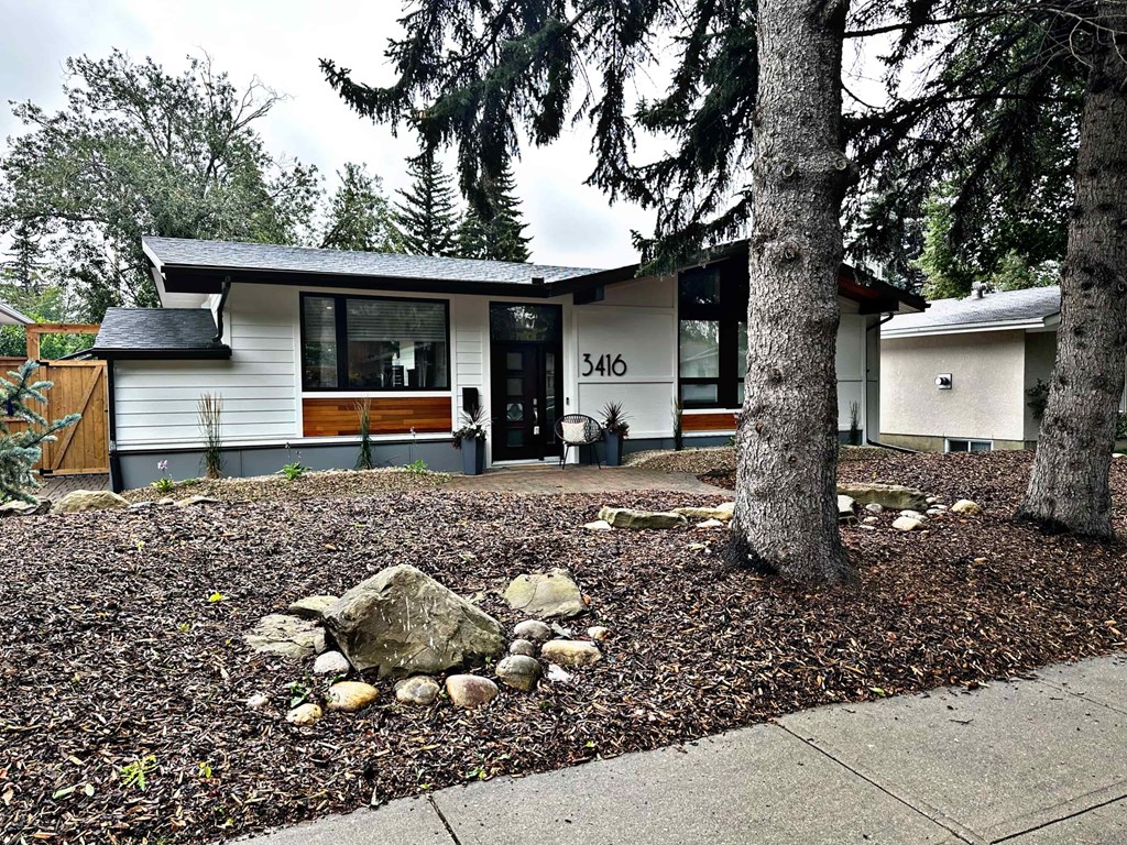 a house with a yard and trees in front of it