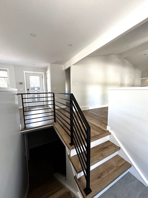 a view of a staircase in a home with white walls and wood floors