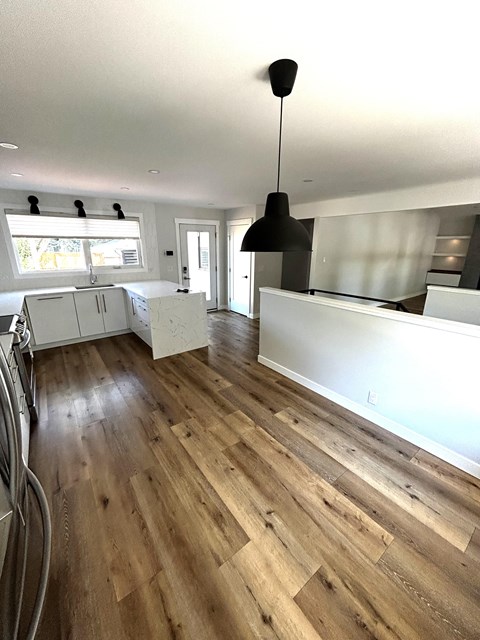 a kitchen with a wooden floor and a white counter top