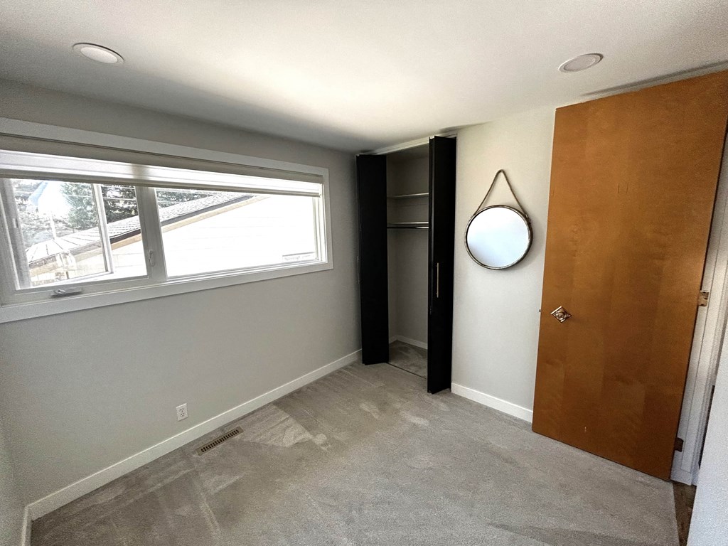 an empty room with a wooden door and a window