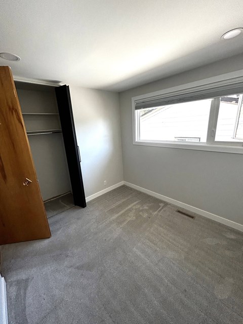 a empty room with a closet and a window