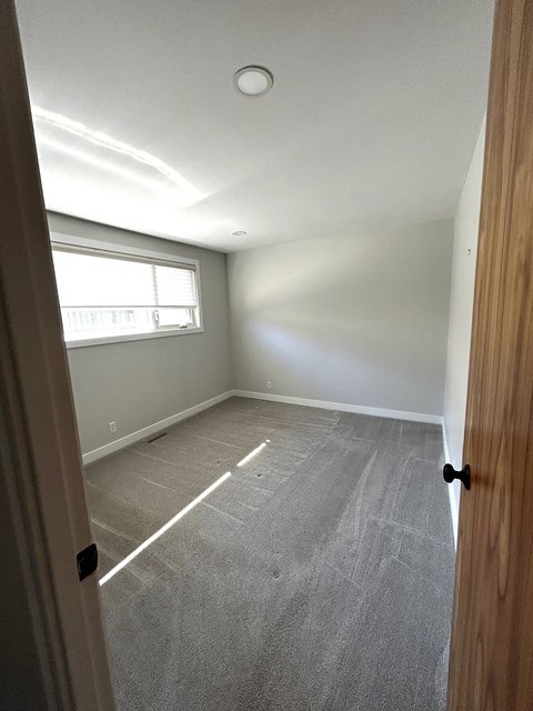 a empty room with the door open and a window