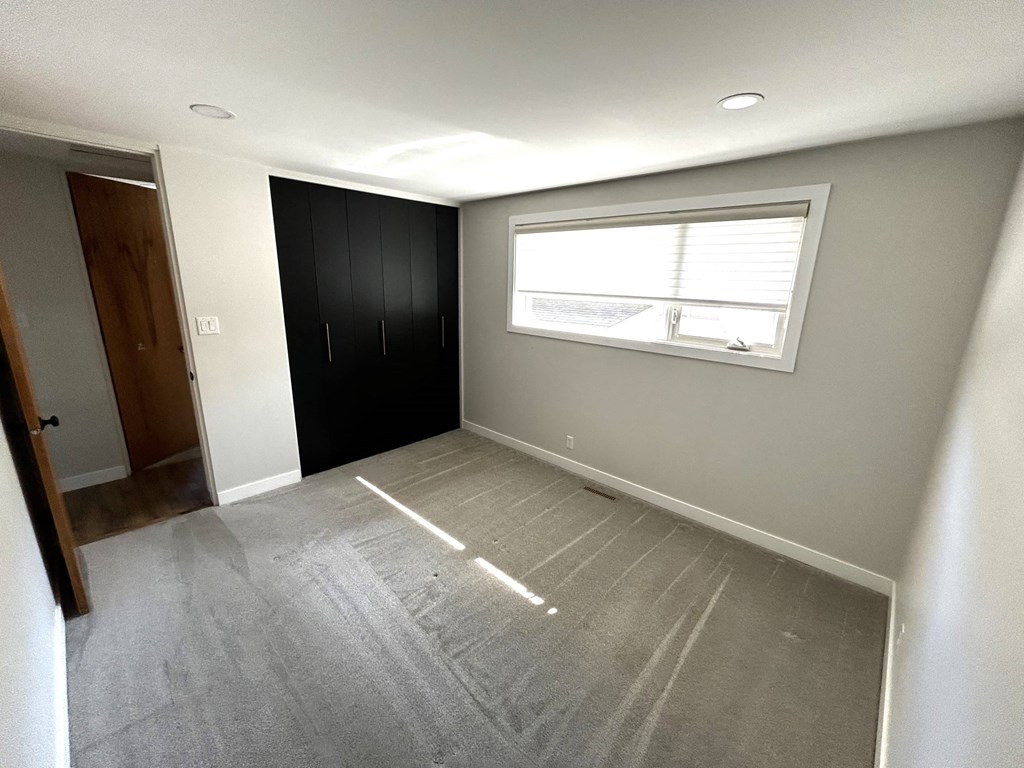 an empty room with a window and a closet