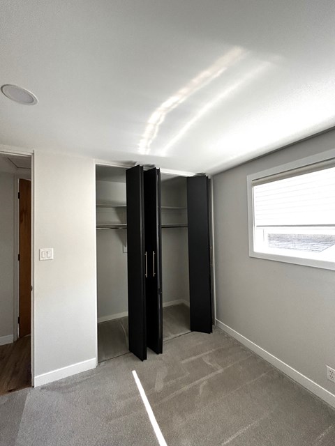 an empty room with a closet and a window