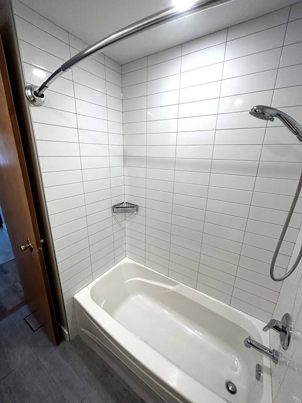 a bathroom with a shower and a white tub