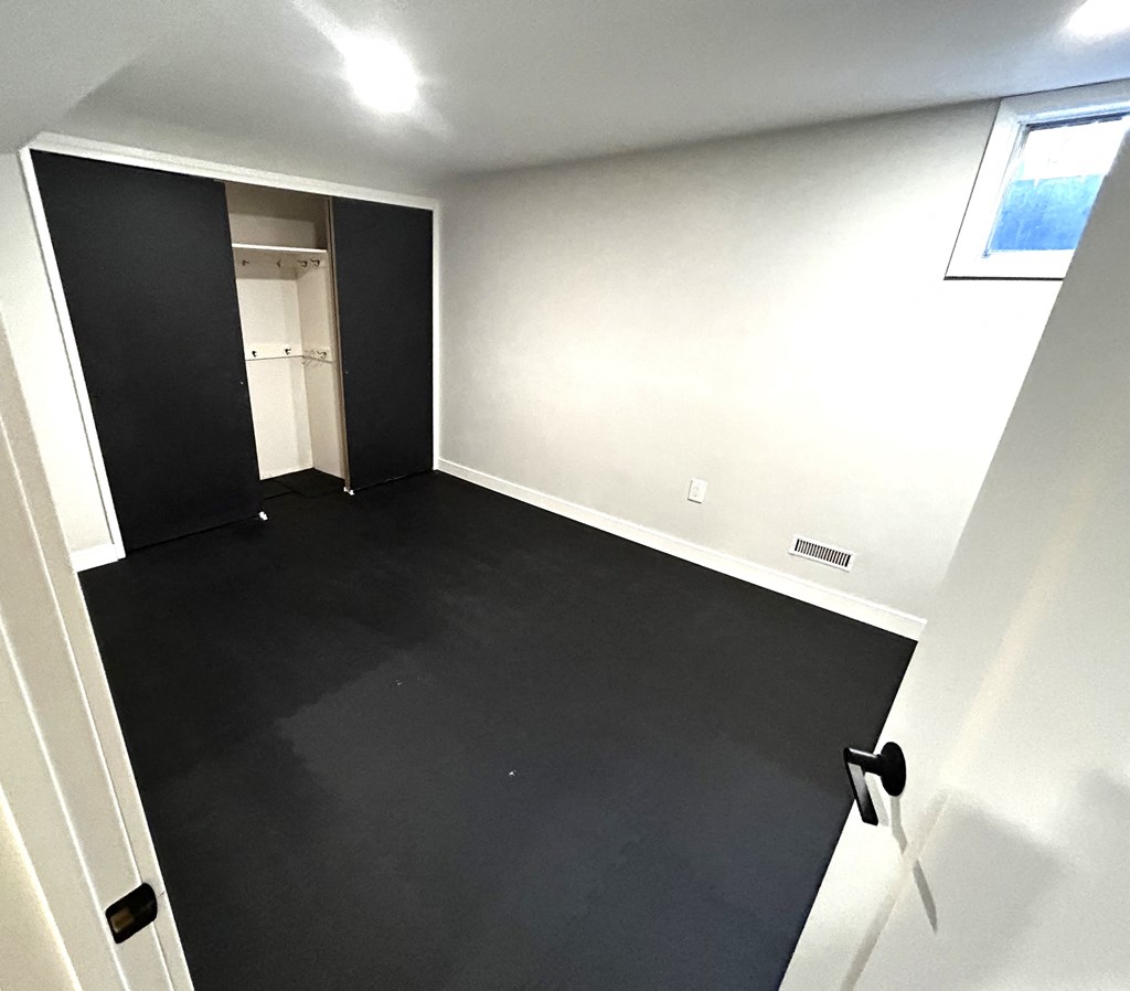 an empty room with black carpet and a closet
