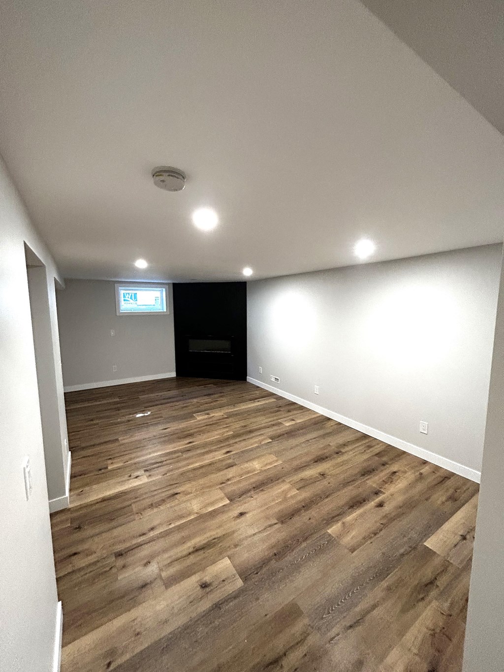 a living room with wood flooring and white walls