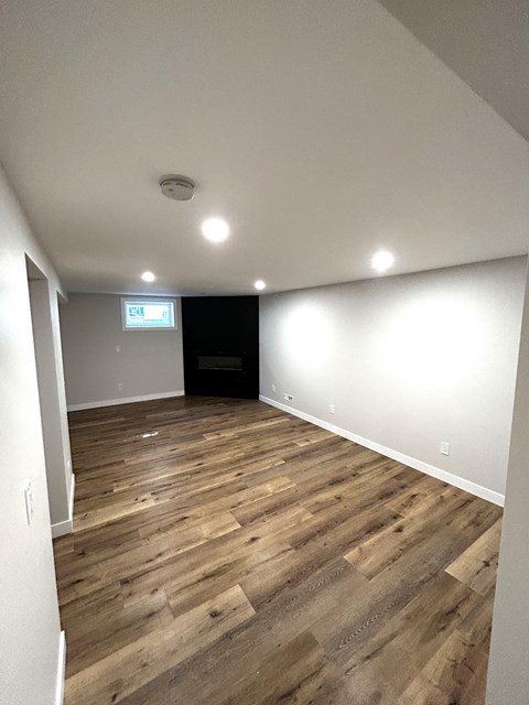 a living room with wood flooring and white walls