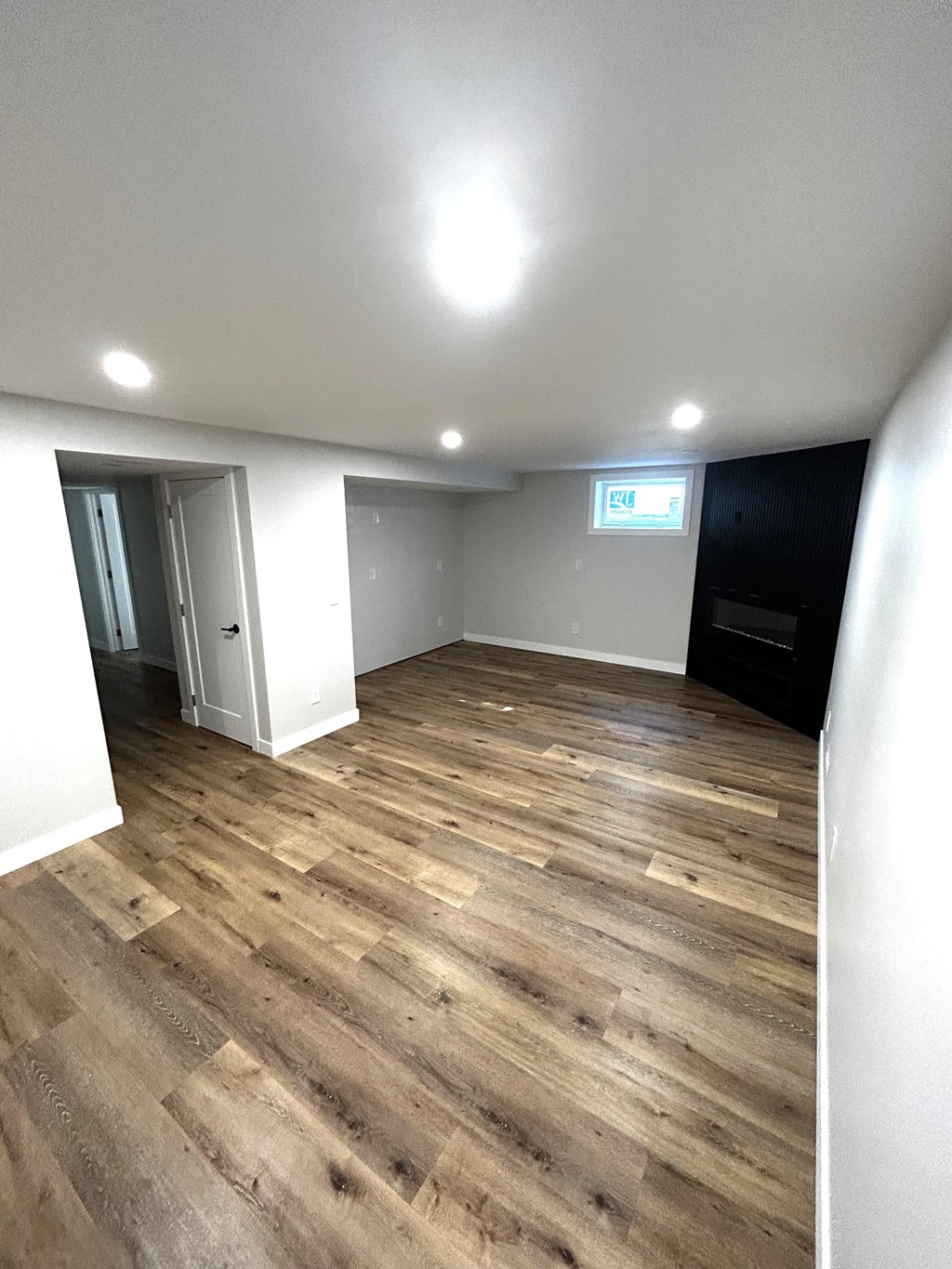 a living room with hardwood floors and white walls