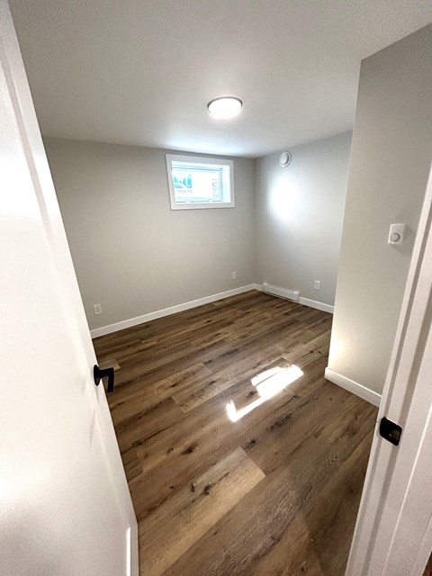 a empty room with wooden floors and a window