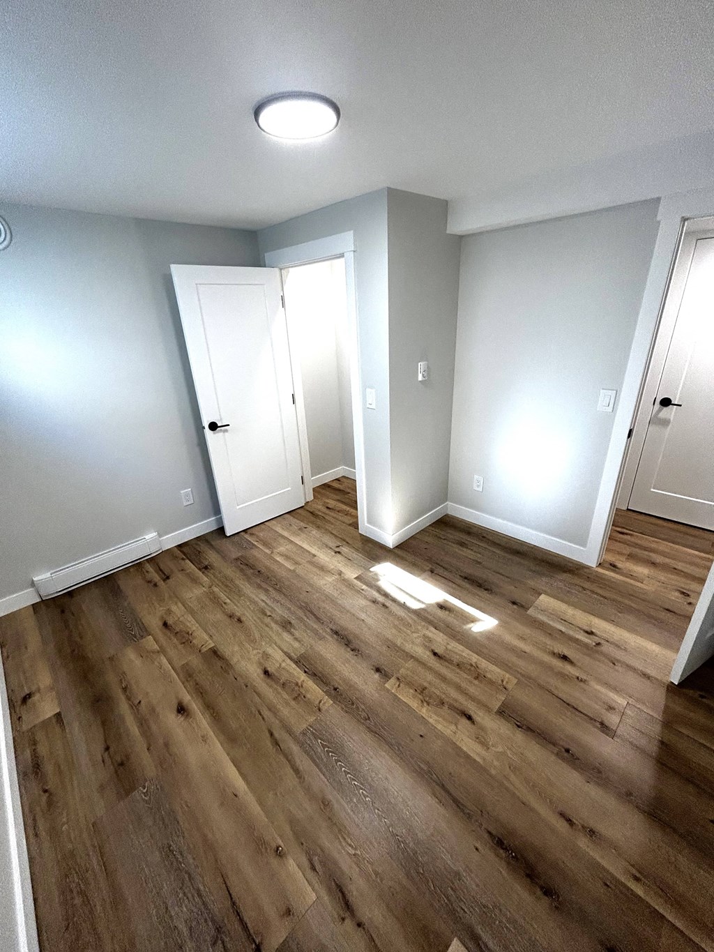 a renovated living room with wood floors and white walls