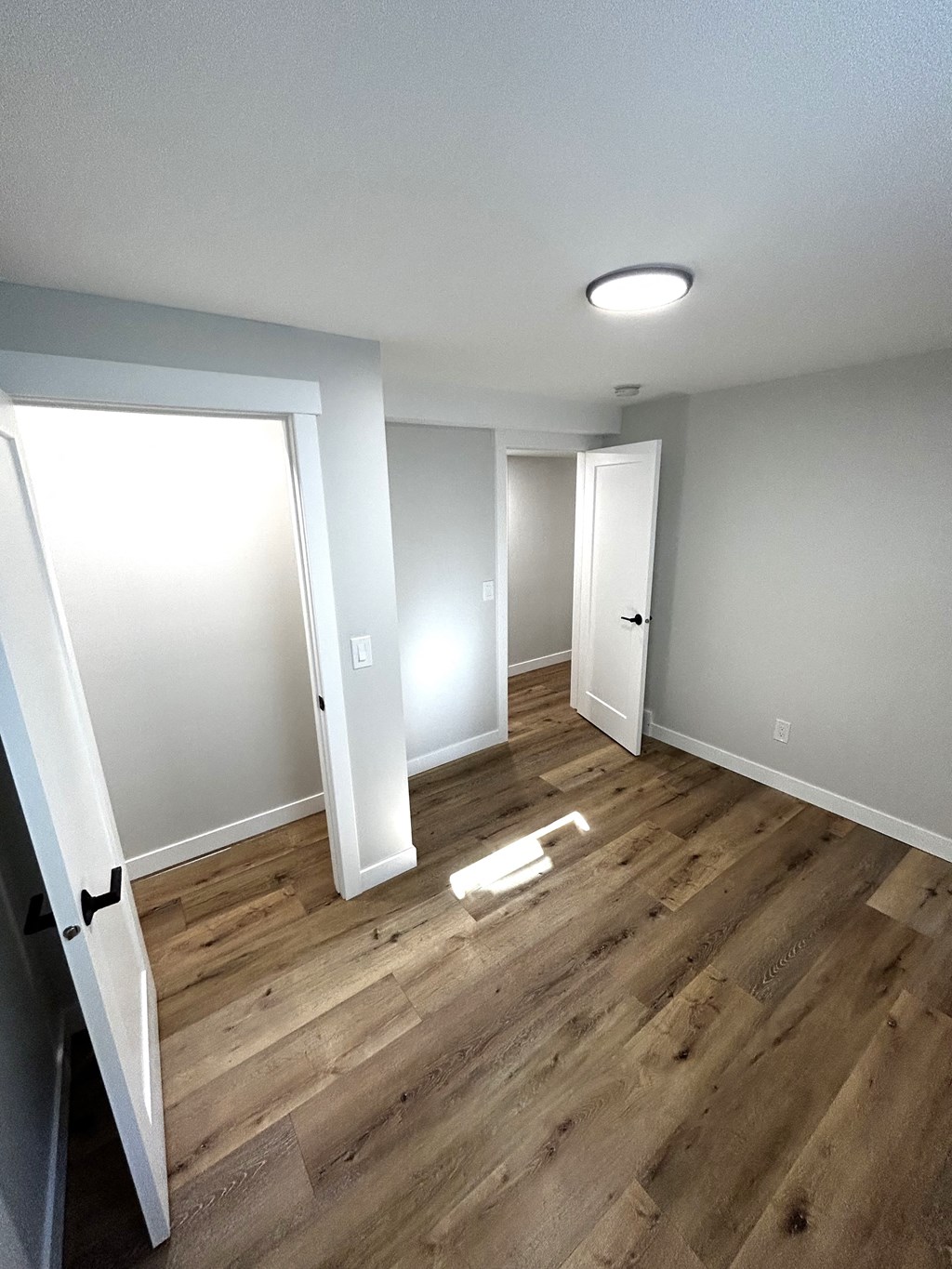 a empty room with wood flooring and white walls