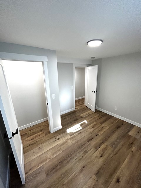 a empty room with wood flooring and white walls