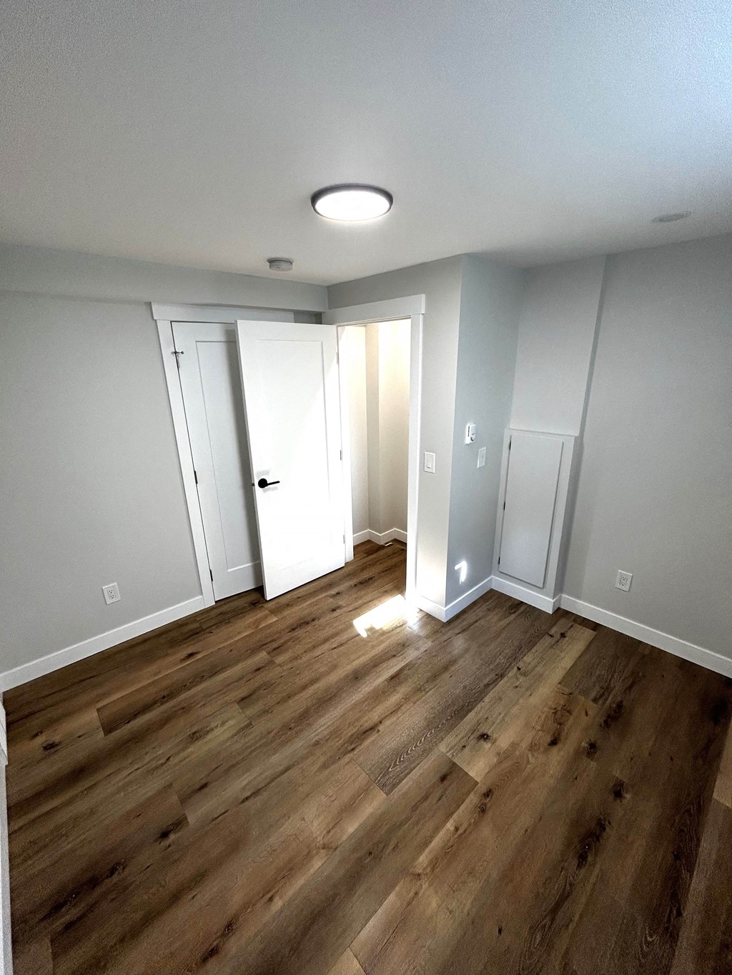 a renovated living room with hardwood floors and white walls