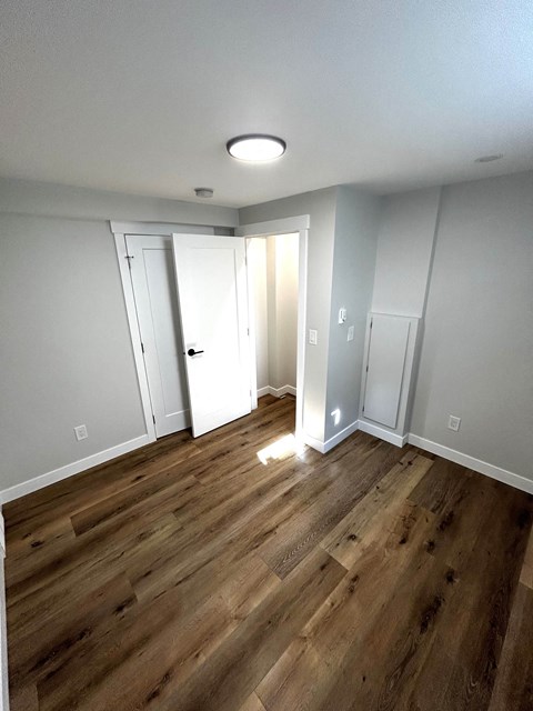 a renovated living room with hardwood floors and white walls
