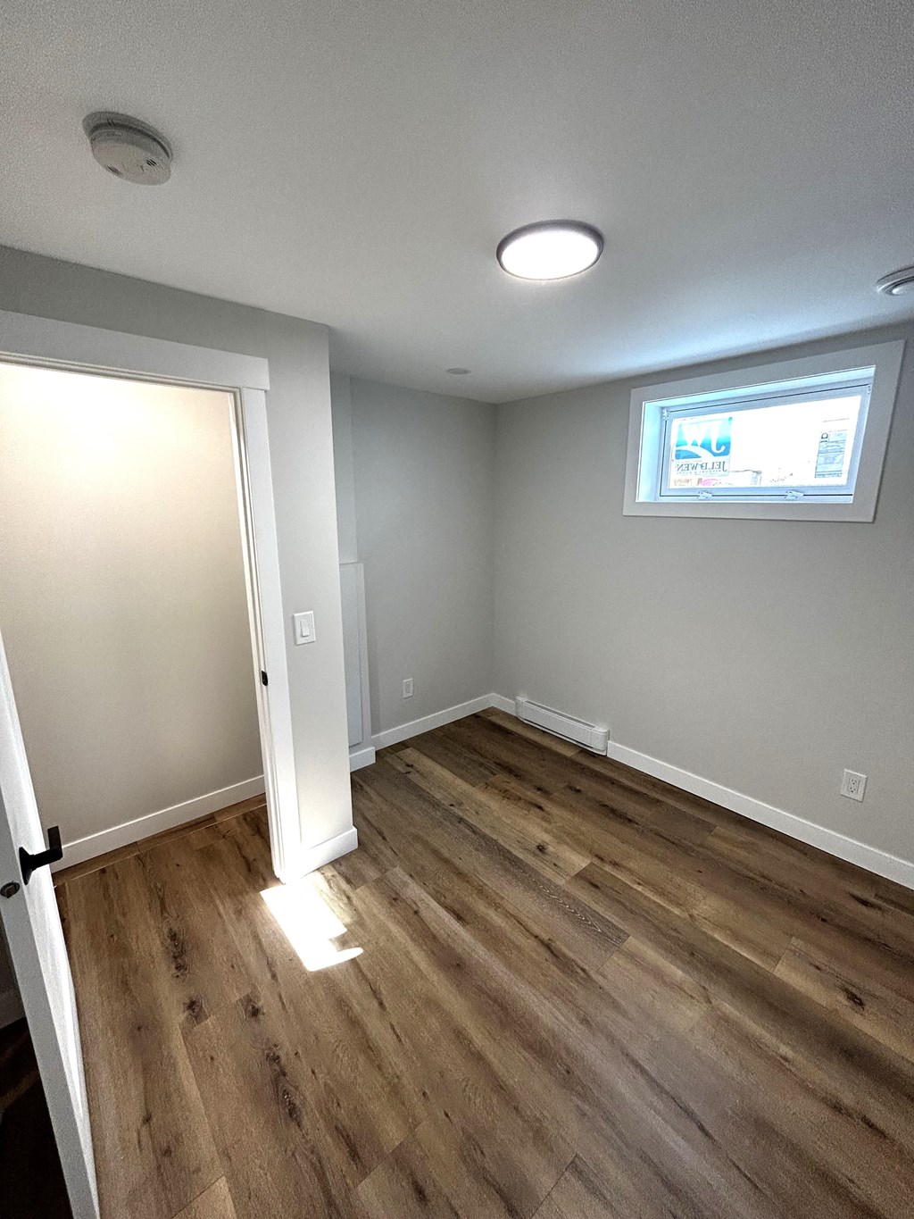 a living room with wooden floors and a window