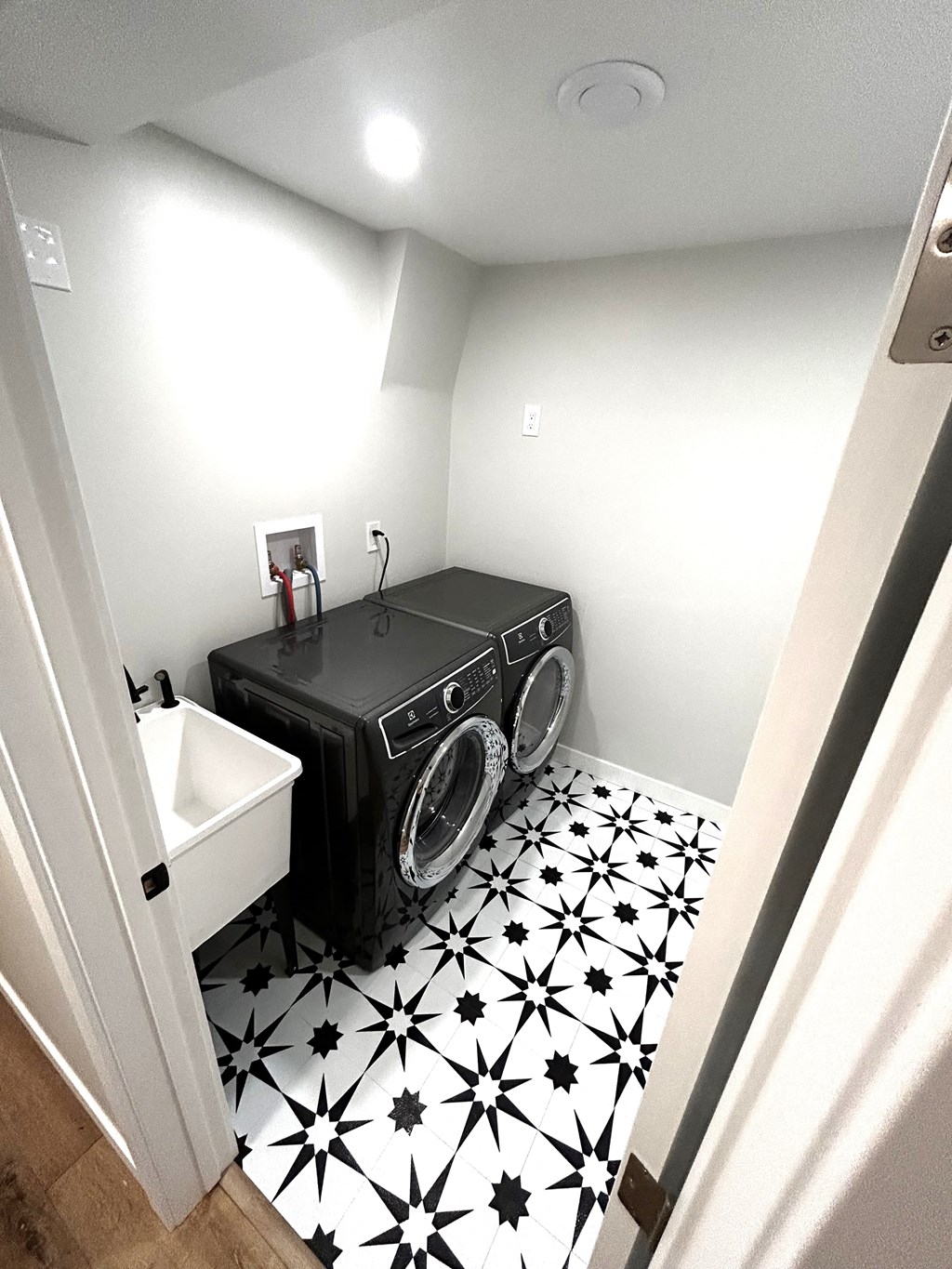 a small laundry room with a washing machine and a sink