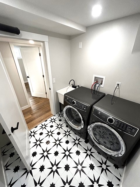 a small laundry room with a washing machine and a sink