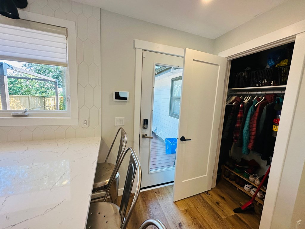 a small kitchen with a door to a closet and a window