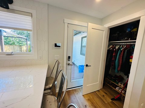 a small kitchen with a door to a closet and a window