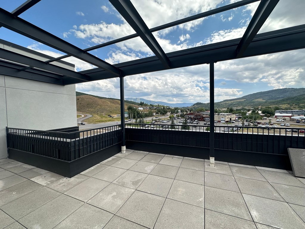 a balcony with a view of a city and a cloudy sky