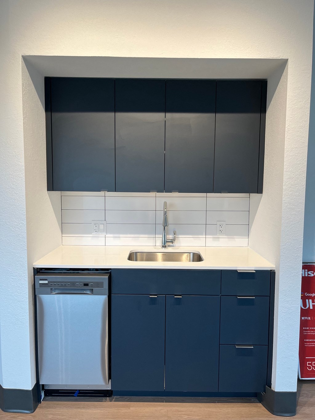 a kitchen with blue cabinets and a white counter top and a dishwasher