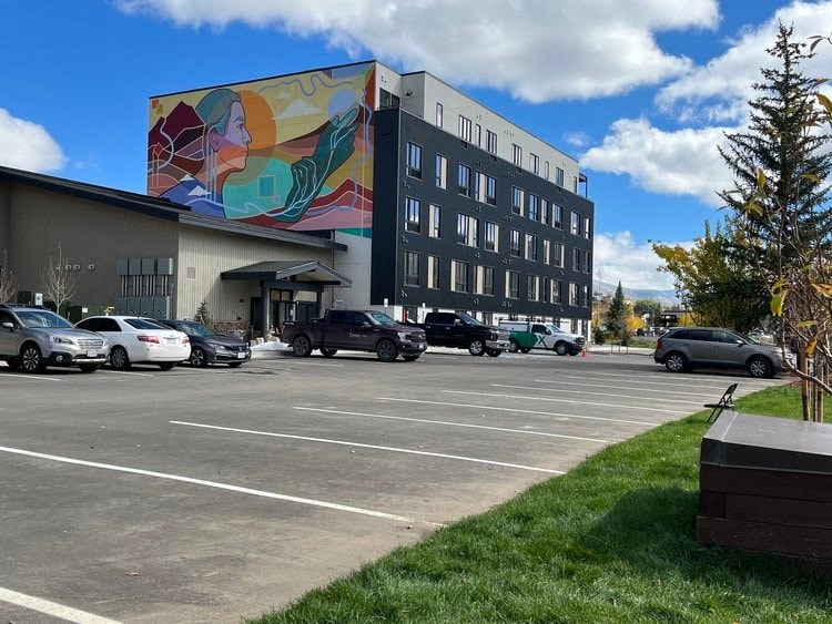 a mural on the side of a building in a parking lot
