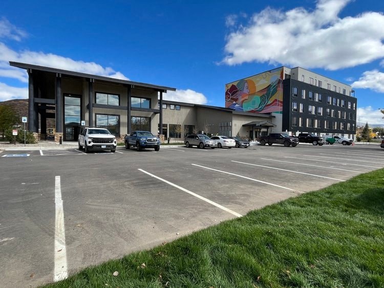 a parking lot with cars in front of a building