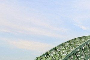 a green bridge over a body of water