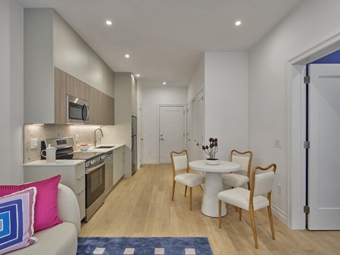 a living room and kitchen with a table and chairs